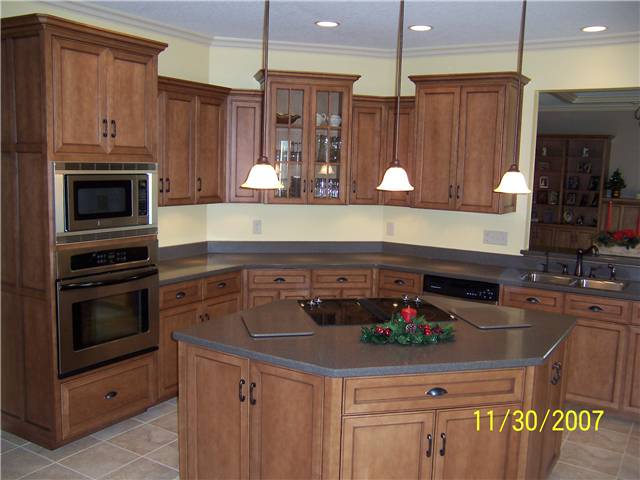 Maple cabinets stained with a glaze finish - Flat panel miter corner doors, drawer fronts, and side panels - Full overlay style - Corian solid surface countertops